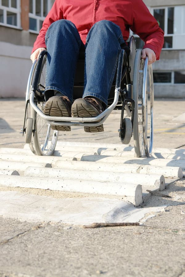 Closeup of handicapped woman practicing wheelchair riding over obstacle course for disabled. Closeup of handicapped woman practicing wheelchair riding over obstacle course for disabled