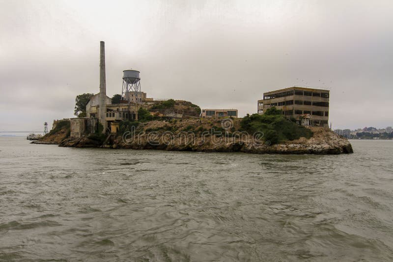 Cruising past Alcatraz Island and the Prison with the military fortifications in San Francisco Bay, USA on a cloudy day. Cruising past Alcatraz Island and the Prison with the military fortifications in San Francisco Bay, USA on a cloudy day