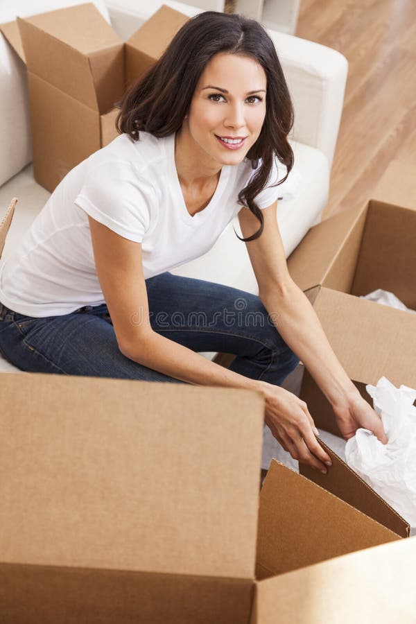 Única mulher que desembala as caixas de embalagem que movem a casa imagem de stock royalty free Única mulher que desembala as caixas de embalagem que movem a casa imagem de stock royalty free