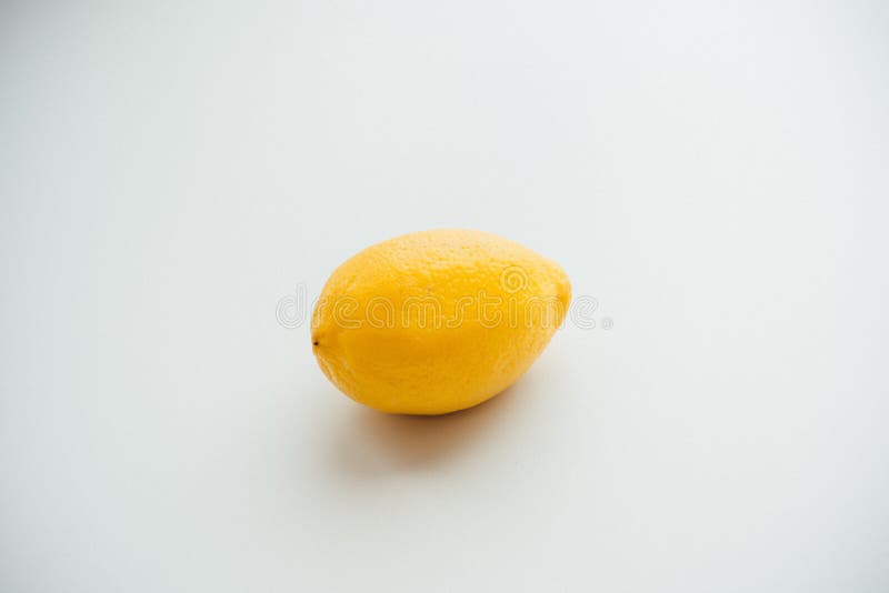 Único isolou o limão fresco amarelo em uma superfície branca e em um fundo branco imagem de stock Único isolou o limão fresco amarelo em uma superfície branca e em um fundo branco imagem de stock