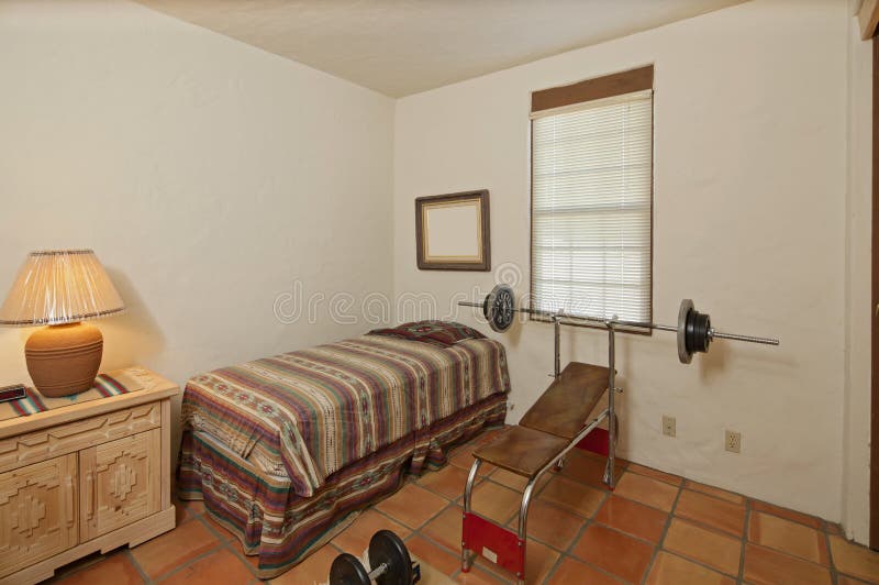 Único quarto pequeno com imprensa e pesos de banco fotos de stock Único quarto pequeno com imprensa e pesos de banco fotos de stock