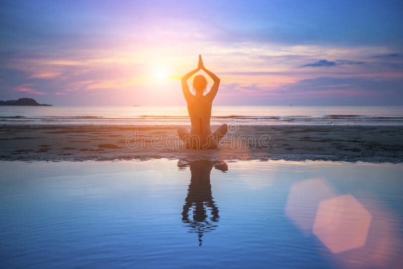 Übendes Yoga der jungen Frau des Schattenbildes auf Strand lizenzfreie stockbilder Übendes Yoga der jungen Frau des Schattenbildes auf Strand lizenzfreie stockbilder