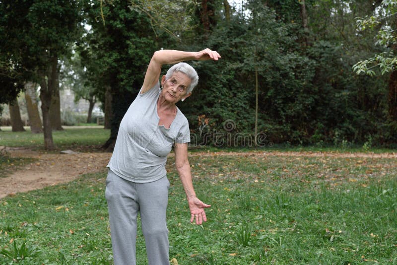 Übendes Yoga der älteren Frau draußen lizenzfreies stockfoto Übendes Yoga der älteren Frau draußen lizenzfreies stockfoto
