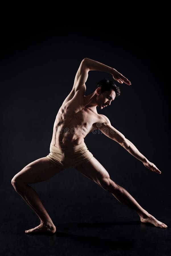 Übendes Yoga des gutaussehenden Mannes in der Dunkelheit beleuchtete Studio lizenzfreies stockfoto Übendes Yoga des gutaussehenden Mannes in der Dunkelheit beleuchtete Studio lizenzfreies stockfoto