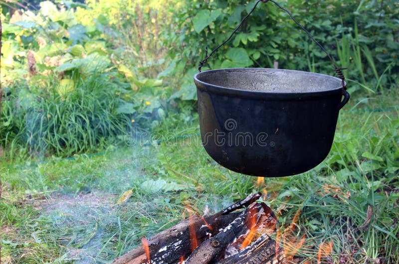 Über dem Feuer hängt eine kochende Schüssel lizenzfreie stockbilder Über dem Feuer hängt eine kochende Schüssel lizenzfreie stockbilder