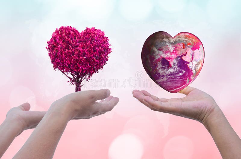 Übergeben Sie das Halten der Erde und der Bäume, die rosa Herz der Form auf verwischt lizenzfreie stockbilder Übergeben Sie das Halten der Erde und der Bäume, die rosa Herz der Form auf verwischt lizenzfreie stockbilder