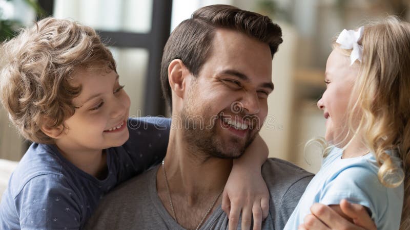 Überglücklicher junger Papa haben Spaß mit Kleinkindern lizenzfreies stockbild