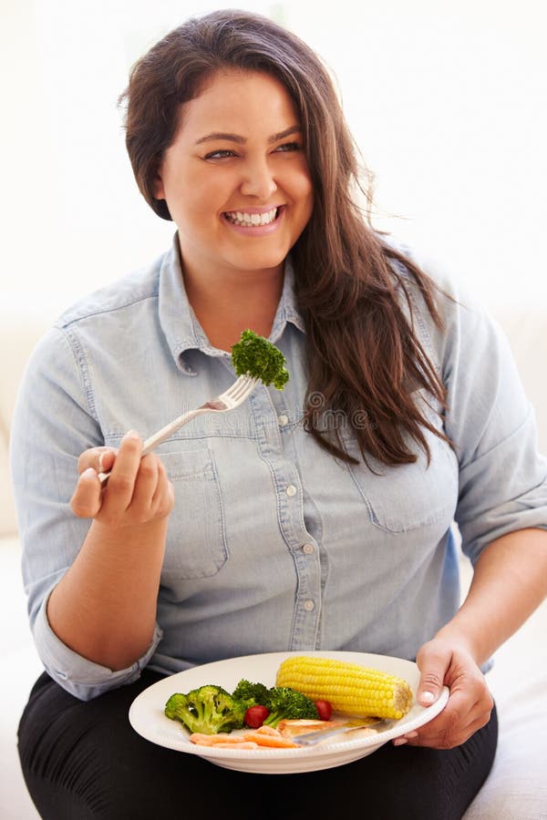 Overweight Woman Eating Healthy Meal Sitting On Sofa. Overweight Woman Eating Healthy Meal Sitting On Sofa