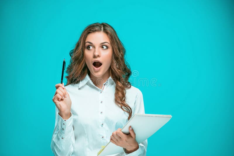 Überraschte junge Geschäftsfrau mit Tablette für Anmerkungen über blauen Hintergrund stockfotos Überraschte junge Geschäftsfrau mit Tablette für Anmerkungen über blauen Hintergrund stockfotos