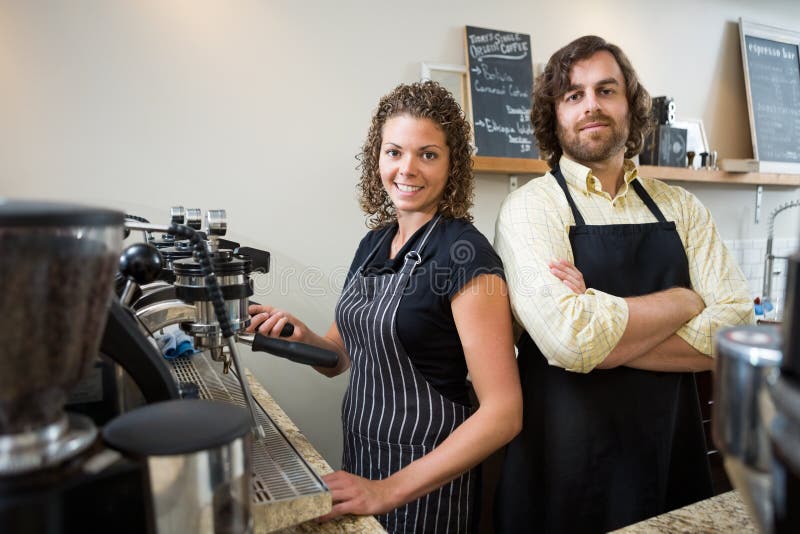Überzeugte Arbeitskräfte am Zähler in Coffeeshop stockfoto Überzeugte Arbeitskräfte am Zähler in Coffeeshop stockfoto