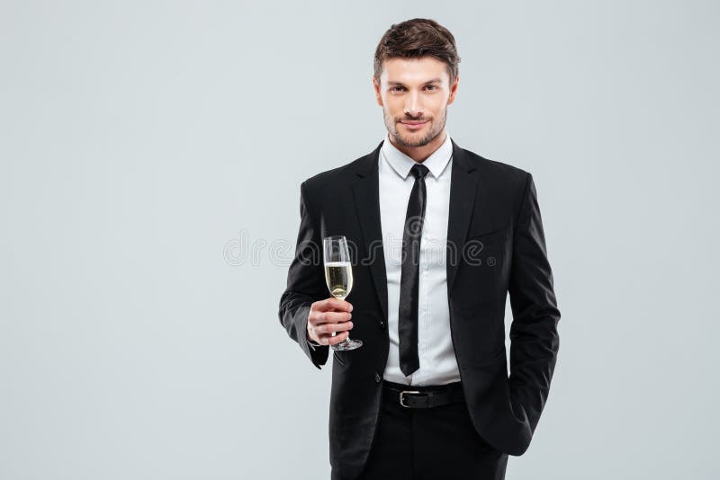 Überzeugter Mann im Anzug und Bindung, die Glas Champagner hält lizenzfreie stockbilder Überzeugter Mann im Anzug und Bindung, die Glas Champagner hält lizenzfreie stockbilder