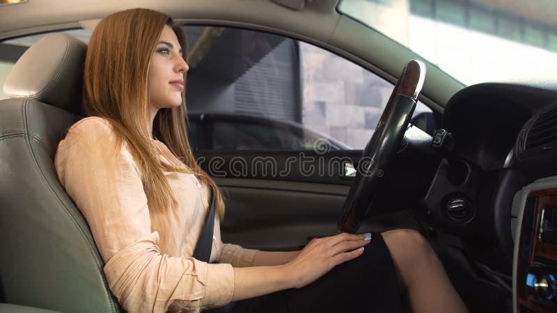 Überzeugtes businesslady Sitzen in gerade gekauftem Auto, bequemer Fahrersitz stockfotos Überzeugtes businesslady Sitzen in gerade gekauftem Auto, bequemer Fahrersitz stockfotos