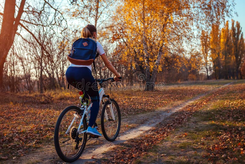 Ćwiczenia dotyczące jazdy rowerowej w jesiennym parku Młoda jeźdźca na rowerze w jesiennym lesie