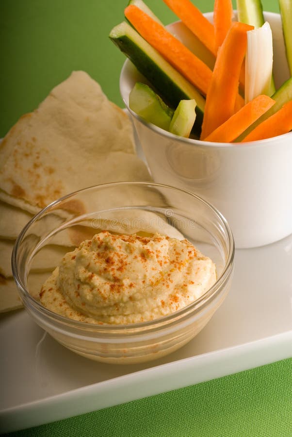Middle eastern hummus dip on a glass bowl with homemade pita brad and raw vegetable. Middle eastern hummus dip on a glass bowl with homemade pita brad and raw vegetable