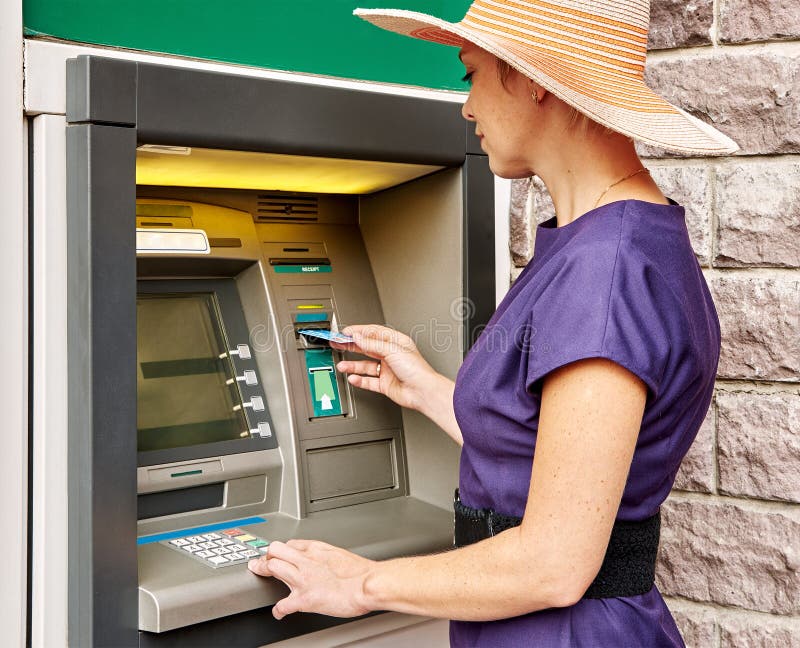 Ładna kobieta działa ATM obraz royalty free Ładna kobieta działa ATM obraz royalty free
