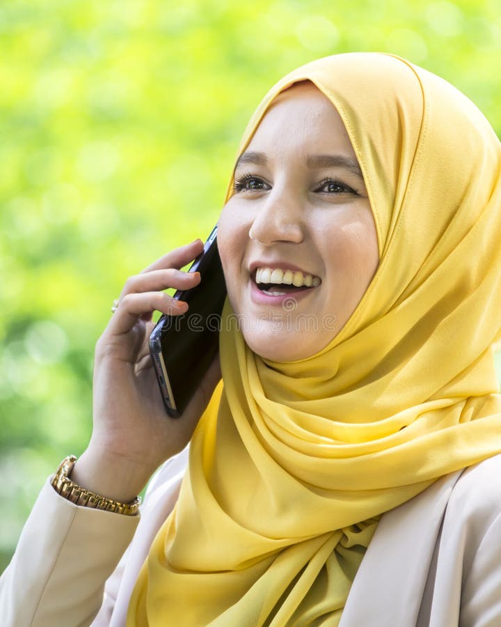Ładna młoda muzułmańska kobieta ma rozmowę na telefonie obrazy stock Ładna młoda muzułmańska kobieta ma rozmowę na telefonie obrazy stock