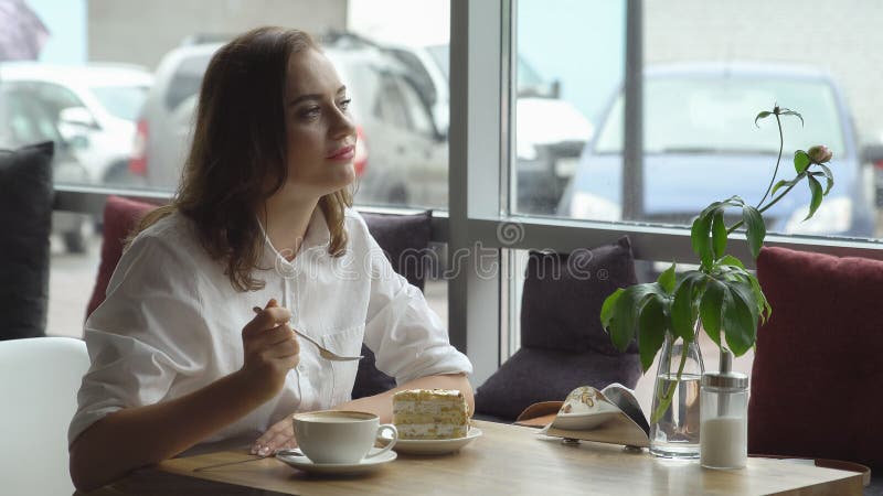 Ładna pije kawa w kawiarni młoda kobieta w biznesie odziewa na przerwa na lunch obraz stock Ładna pije kawa w kawiarni młoda kobieta w biznesie odziewa na przerwa na lunch obraz stock