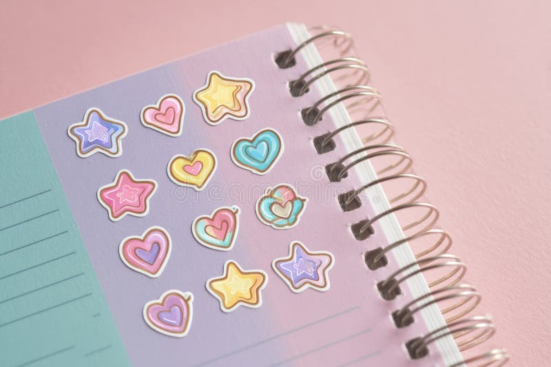 Ładne kleszcze Pastel Kpop inspirowane gwiazdami i sercami są ładnie rozmieszczone na kolorowym notebooku przy miękkim obrazy stock