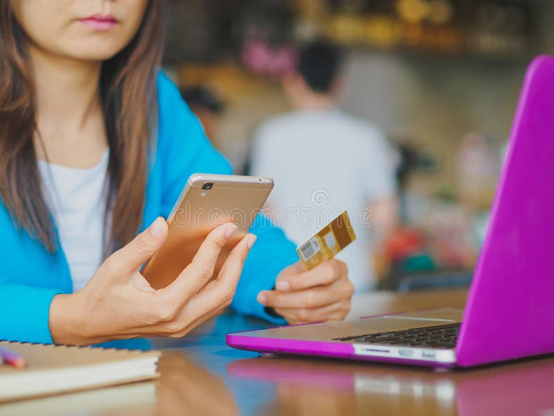 Ładne młodych kobiet ręki trzyma kredytową kartę i używa smartphone dla online zakupy obrazy royalty free