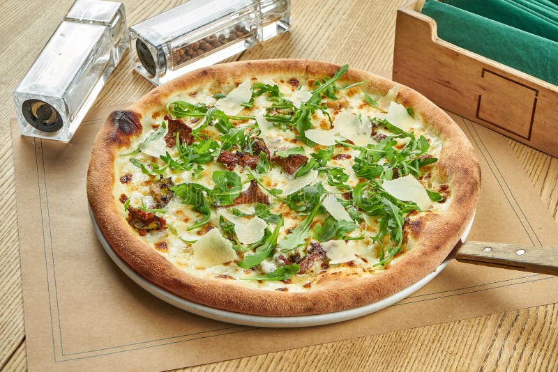 łaknąca pieczona pizza z dzikimi grzybami parmezan i arugula z chrupiącą skórką na drewnianym tle. stół restauracyjny zdjęcia stock