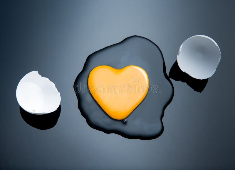 Broken egg and yolk with heart shaped yolk. Broken egg and yolk with heart shaped yolk