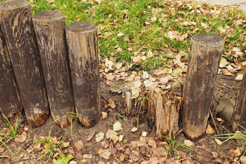 Łamany ogrodzenie, stary drewniany stockade, częstokół, trawa w tle Jesień liście zdjęcie stock Łamany ogrodzenie, stary drewniany stockade, częstokół, trawa w tle Jesień liście zdjęcie stock
