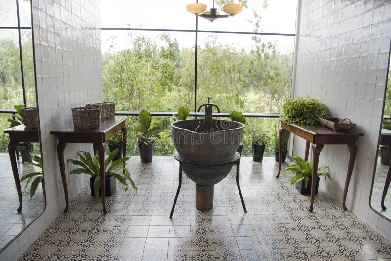 Unique bathroom with old tiles, many plants and beautiful view out of large windows . Unique bathroom with old tiles, many plants and beautiful view out of large windows