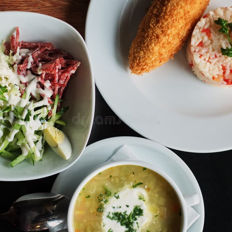 łomotać stół: talerz polewka, risotto z cutlet i warzywo sałatka, zdjęcie royalty free łomotać stół: talerz polewka, risotto z cutlet i warzywo sałatka, zdjęcie royalty free