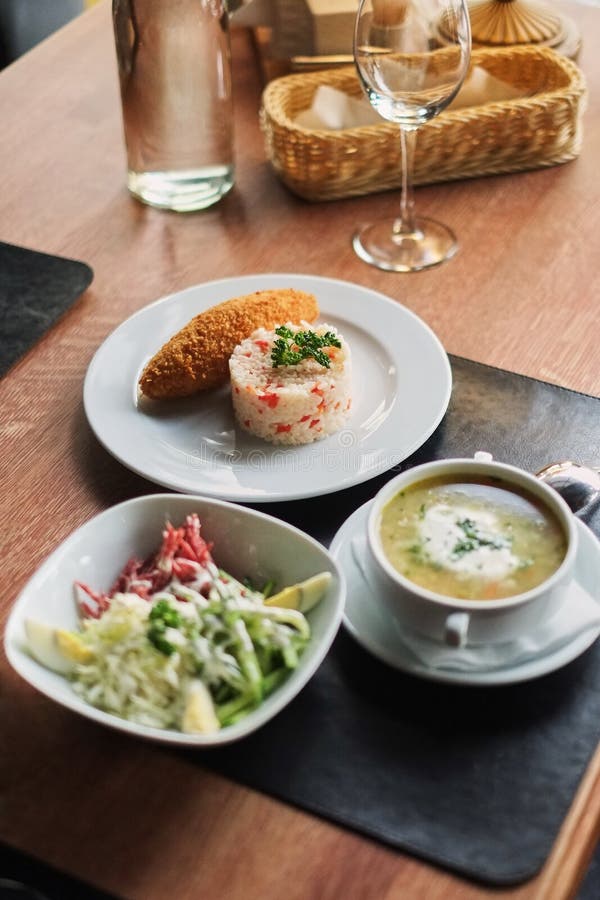 łomotać stół: talerz polewka, risotto z cutlet i warzywo sałatka, obrazy royalty free łomotać stół: talerz polewka, risotto z cutlet i warzywo sałatka, obrazy royalty free