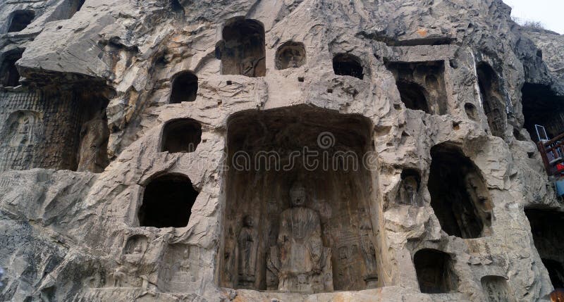 Longmen grottoes with several niches carved in the wall at the face of a mountain, buddhist temple whit several sculptures in it. Longmen grottoes with several niches carved in the wall at the face of a mountain, buddhist temple whit several sculptures in it