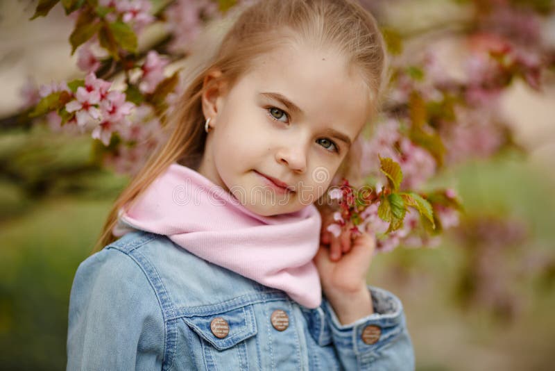 Śliczna blondynki dziewczyna ono uśmiecha się przeciw tłu różani Sakura bu obrazy royalty free Śliczna blondynki dziewczyna ono uśmiecha się przeciw tłu różani Sakura bu obrazy royalty free