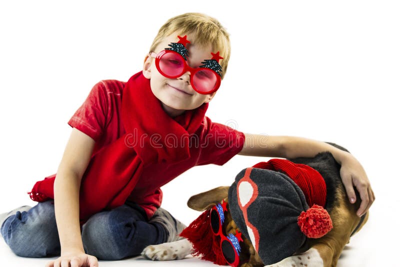 Śliczna chłopiec i śmieszny beagle pies w świątecznych okularach przeciwsłonecznych zdjęcie stock Śliczna chłopiec i śmieszny beagle pies w świątecznych okularach przeciwsłonecznych zdjęcie stock