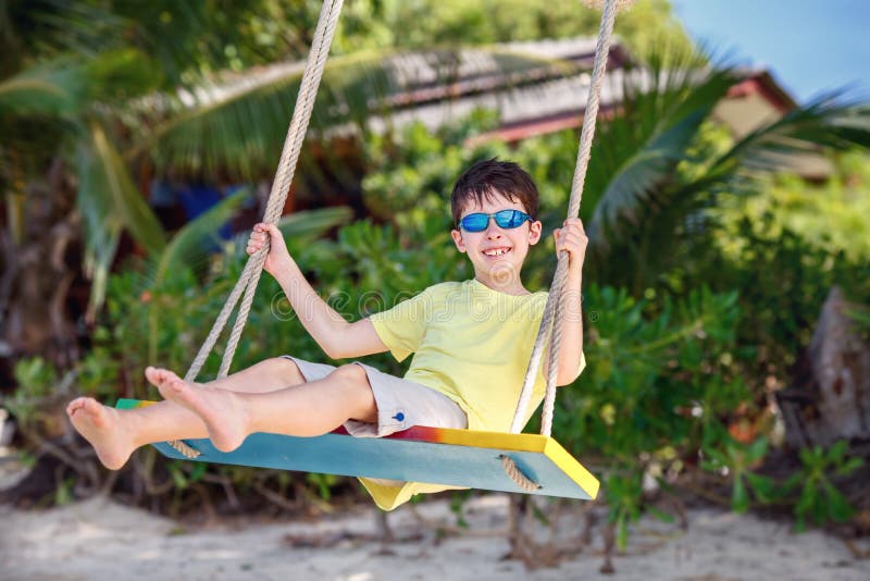 Śliczna chłopiec ma zabawy chlanie przy tropikalną wyspy plażą zdjęcie stock Śliczna chłopiec ma zabawy chlanie przy tropikalną wyspy plażą zdjęcie stock