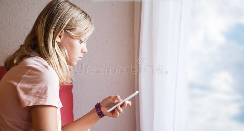 Śliczna Kaukaska blond nastoletnia dziewczyna używa smartphone zdjęcia stock