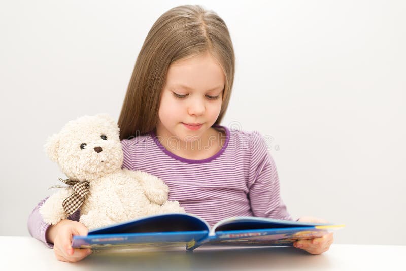 Śliczna mała dziewczynka czyta książkę