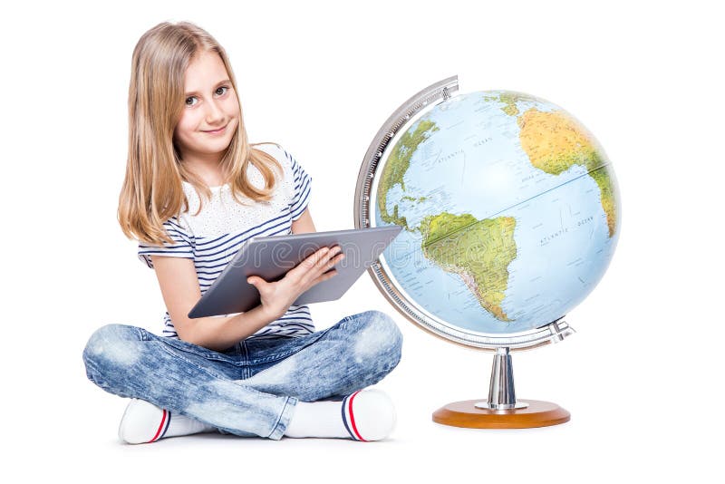 śliczna mała młoda dziewczyna z pastylką i kulą ziemską Uczennica używa nowożytną technologię w nauczanie geografii