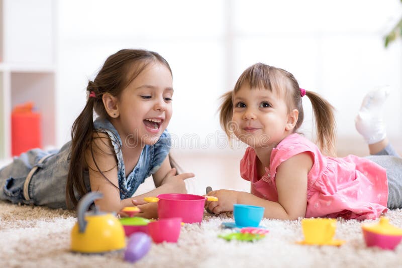 Śliczni małe dzieci bawić się z kitchenware podczas gdy kłamający na podłoga w domu fotografia stock Śliczni małe dzieci bawić się z kitchenware podczas gdy kłamający na podłoga w domu fotografia stock