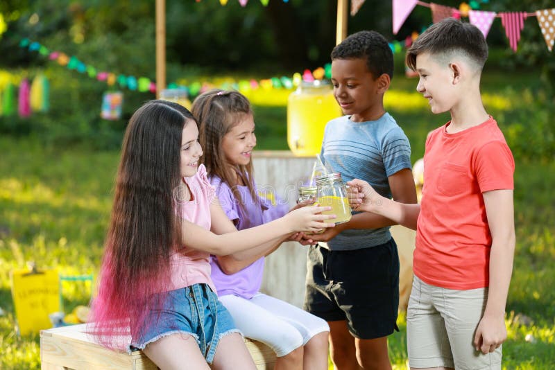 Cute little children with natural lemonade in park. Summer refreshing drink. Cute little children with natural lemonade in park. Summer refreshing drink