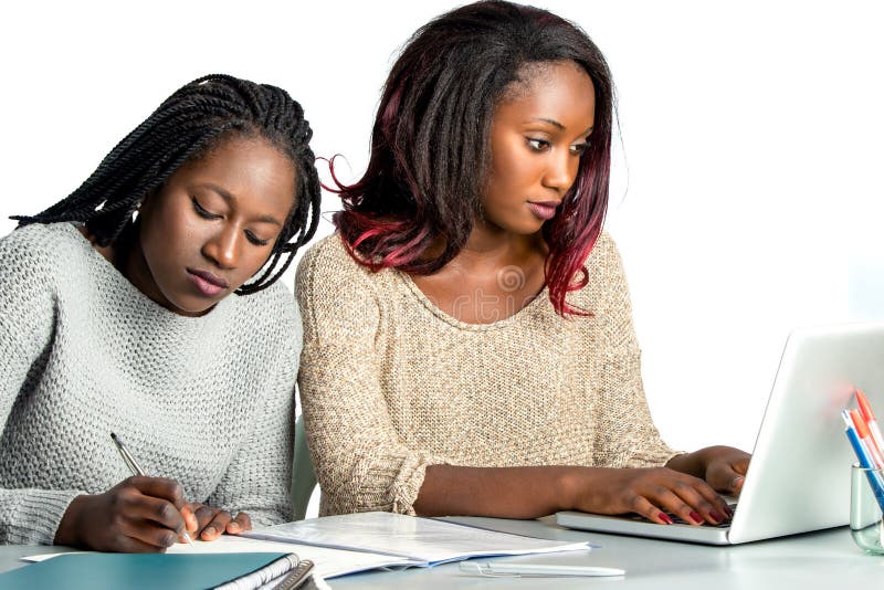Śliczny afrykański nastoletni studencki działanie na laptopie z przyjacielem