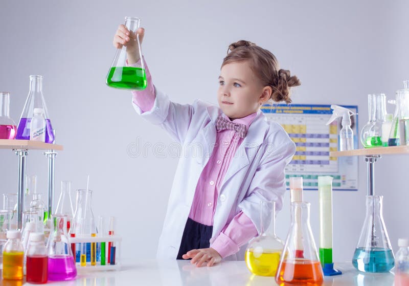 Śliczny chemik egzamininuje tubki z kolorowym odczynnikiem zdjęcie stock