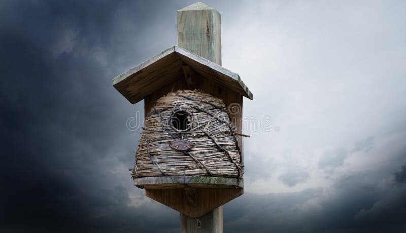 Śliczny drewniany birdhouse z słoma ścianami na drewnianej poczcie fotografia stock Śliczny drewniany birdhouse z słoma ścianami na drewnianej poczcie fotografia stock