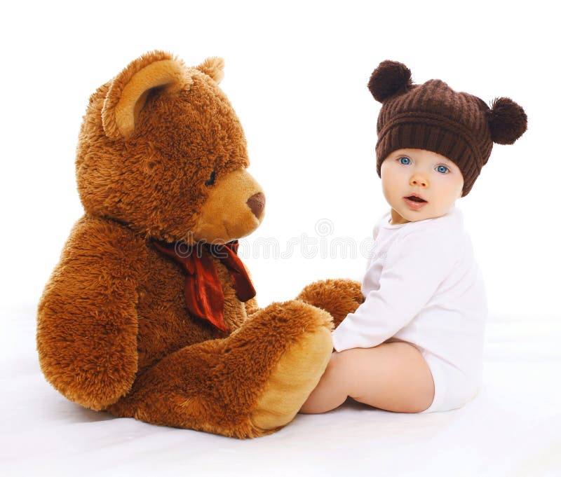 Śliczny dziecko w trykotowym brown kapeluszu z dużym misiem zdjęcie stock Śliczny dziecko w trykotowym brown kapeluszu z dużym misiem zdjęcie stock