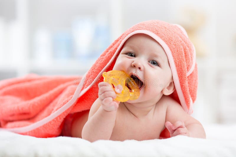 Śliczny dziecko z teether pod kapturzastym ręcznikiem po skąpania obrazy royalty free Śliczny dziecko z teether pod kapturzastym ręcznikiem po skąpania obrazy royalty free