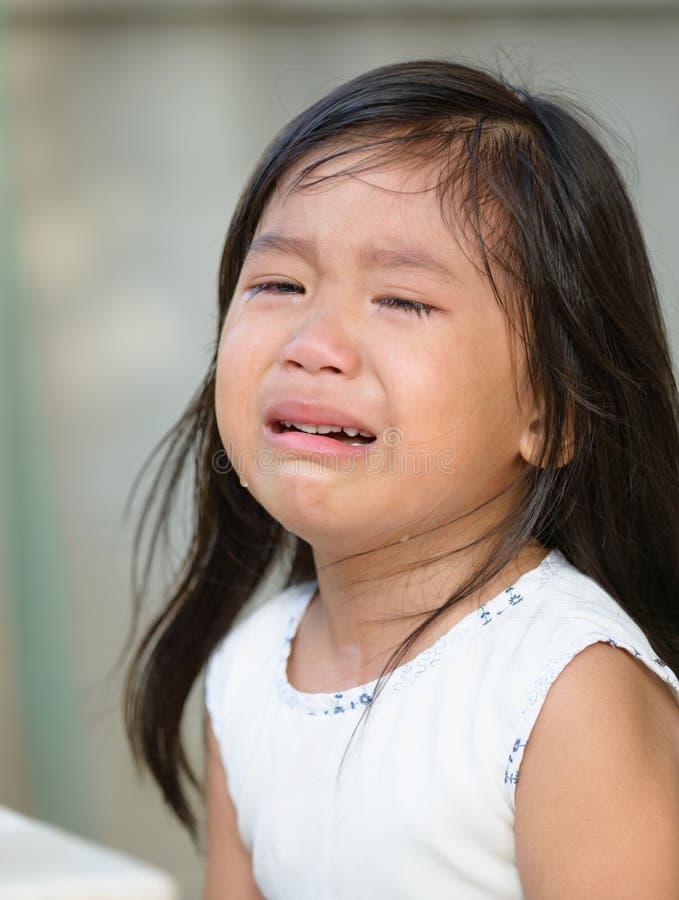 Cute little asian girl crying at home. Cute little asian girl crying at home.