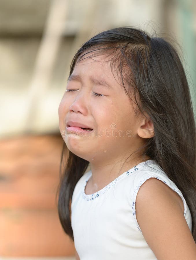 Cute little asian girl crying at home. Cute little asian girl crying at home.