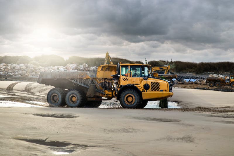 dumper at work on a construction site near a beach. dumper at work on a construction site near a beach