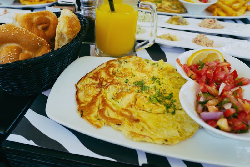 Śniadanie w restauraci z omletem, sałatka, chleb i sok pomarańczowy w instagram, projektujemy obraz stock Śniadanie w restauraci z omletem, sałatka, chleb i sok pomarańczowy w instagram, projektujemy obraz stock