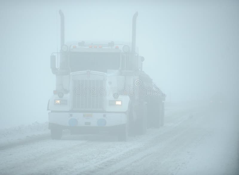 White eighteen wheeler truck in snow white-out, i.e. dangerous driving conditions, Dalton Highway (Arctic Circle), Alaska, US. White eighteen wheeler truck in snow white-out, i.e. dangerous driving conditions, Dalton Highway (Arctic Circle), Alaska, US