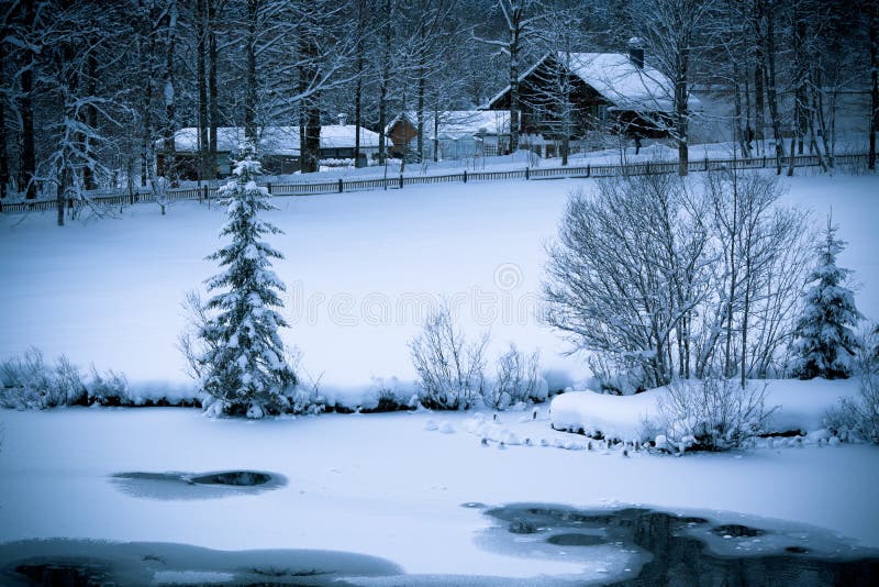 Fairy tale. Snowy Alpine house and frozen river in the woods. Toned and vignetted image as postcard. Fairy tale. Snowy Alpine house and frozen river in the woods. Toned and vignetted image as postcard