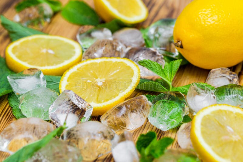 Świezi pokrojona cytryna, jaskrawa - zielona mennica i lód na drewnianym stole Mojito koktajlu bezalkoholowi ingridients Orzeźwie zdjęcia stock Świezi pokrojona cytryna, jaskrawa - zielona mennica i lód na drewnianym stole Mojito koktajlu bezalkoholowi ingridients Orzeźwie zdjęcia stock